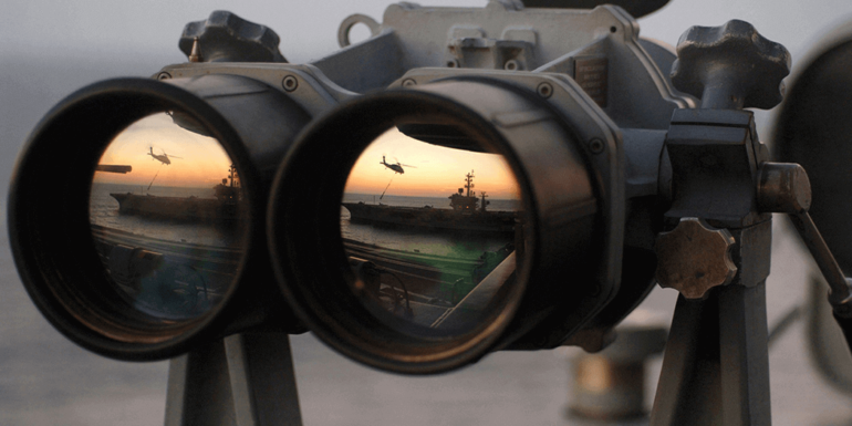 A pair of binoculars overlooking a boat and a helicopter.